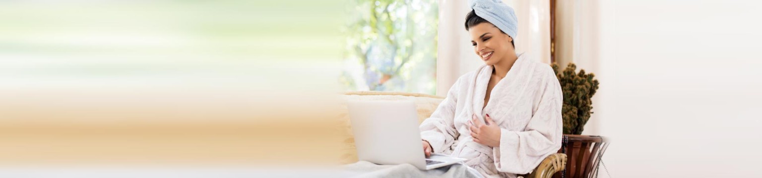Remote Wellness Consultation - Woman on couch on laptop