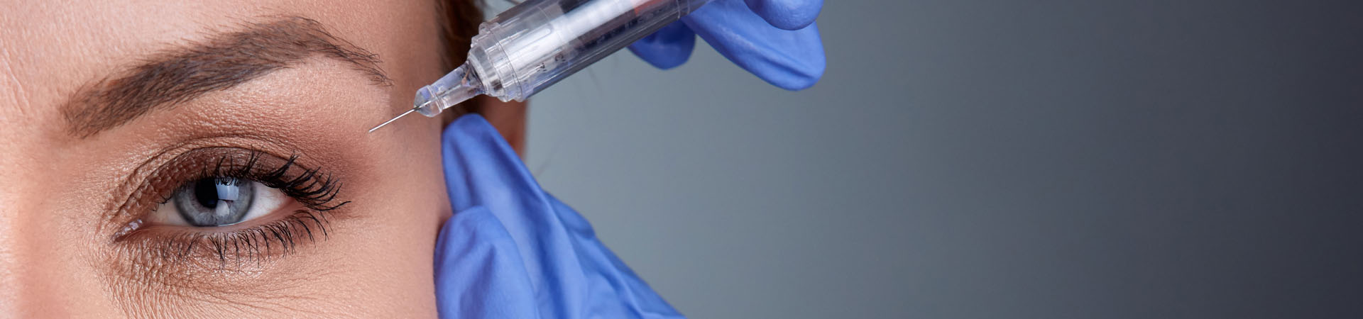 Injectables & Fillers Slider Background - Woman getting shot near her eye
