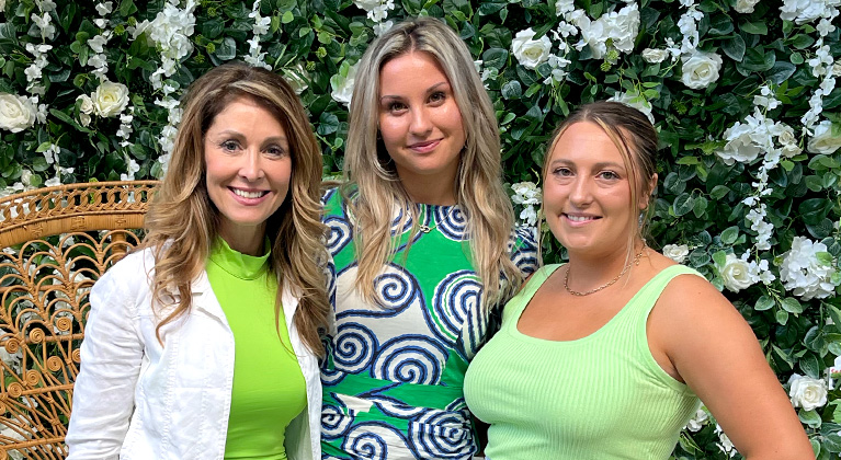 Three beautiful women, with clear summer skin, standing in a garden